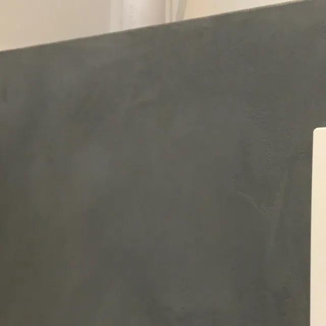 Close-up van een grijze wand met betonlook afwerking